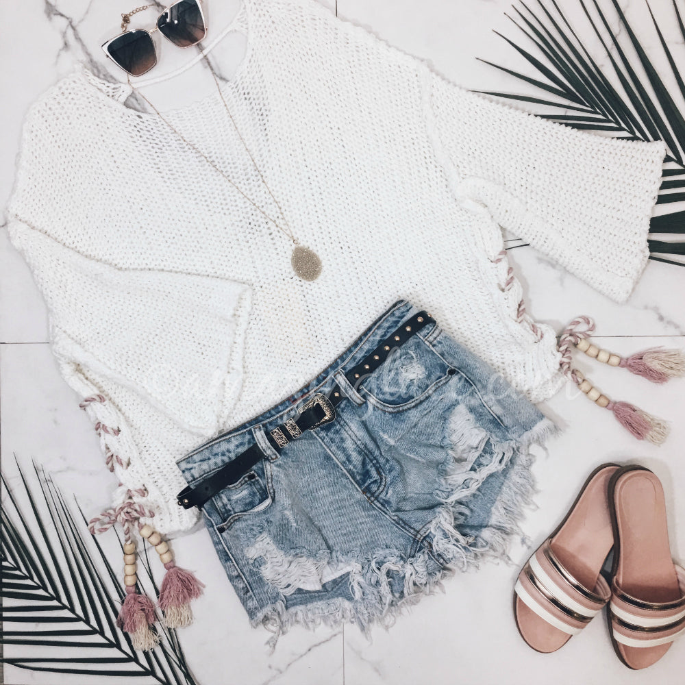 WHITE SWEATER WITH HANGING BRAIDS AND SHORTS OUTFIT