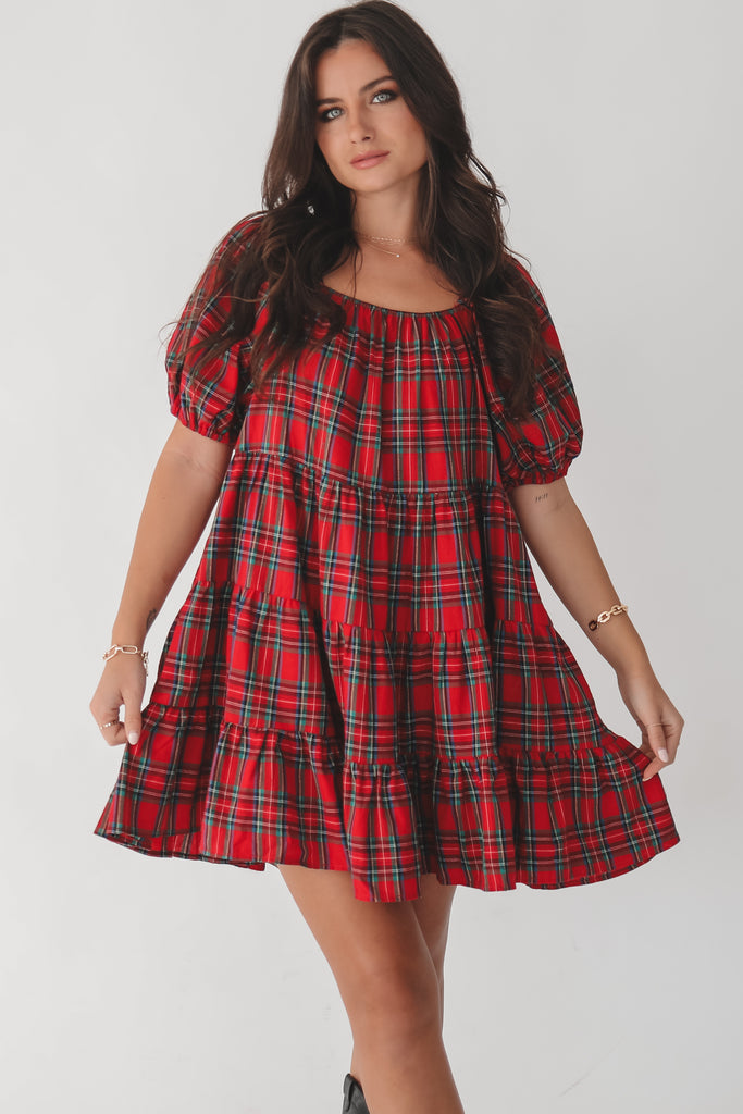 Woman wearing a red plaid dress on a white background