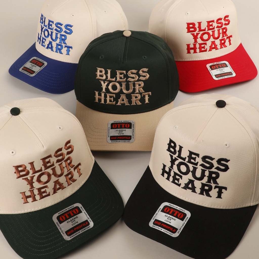 Collection of hats with 'Bless Your Heart' text in various colors on a light background