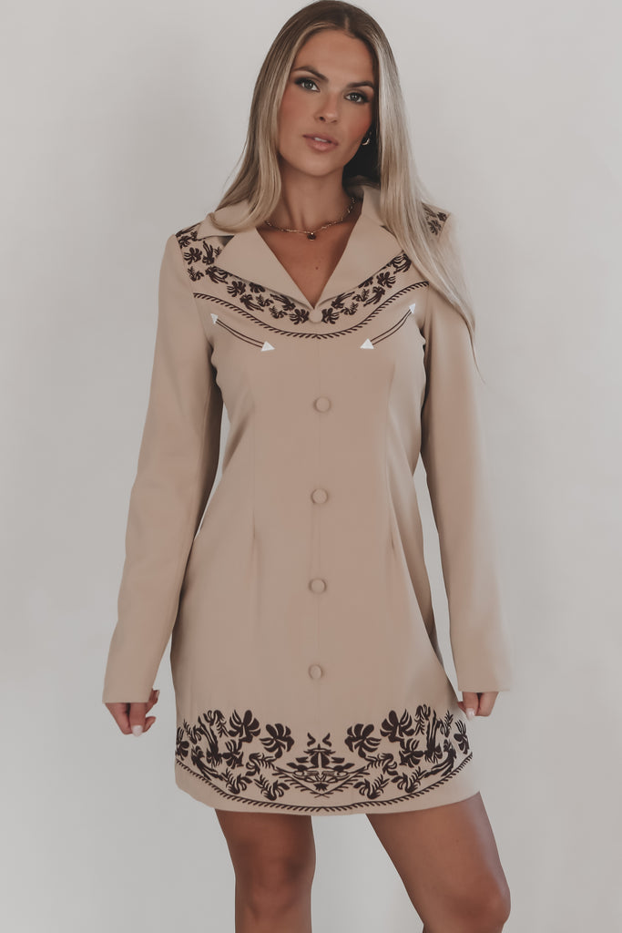 Beige dress with black embroidery on a white background