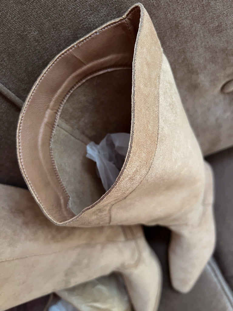 Close-up of beige suede shoe with a brown background